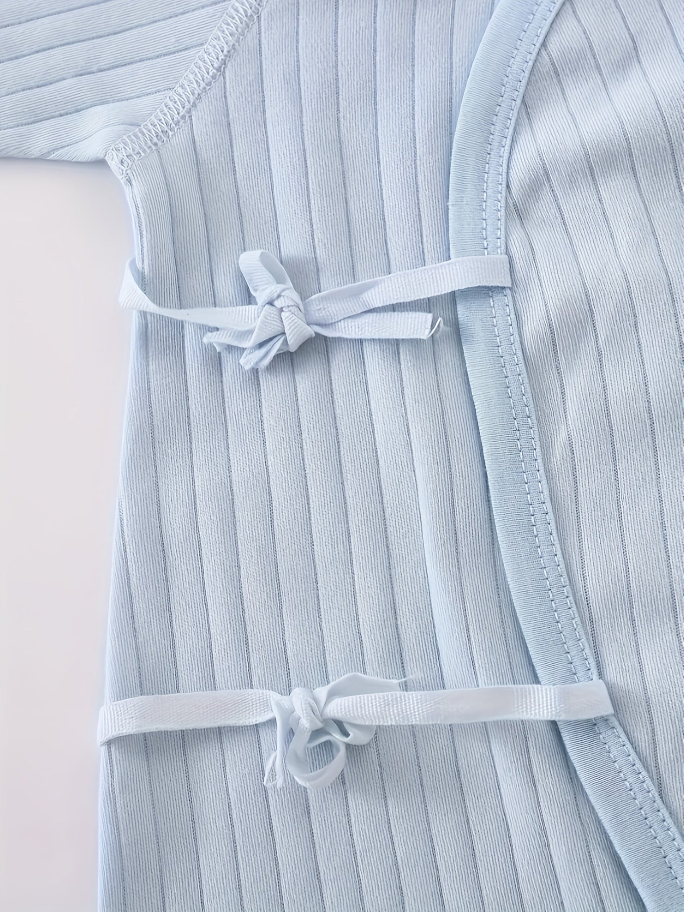 Baby romper featuring a playful bear patch, made from soft cotton for breathability during fall and winter, designed for easy dressing with bows and buttons. 8