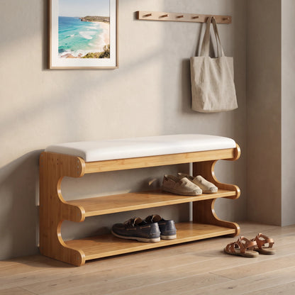 Bamboo shoe storage bench with padded seat in natural finish, featuring a space-saving design ideal for entryway organization. 1
