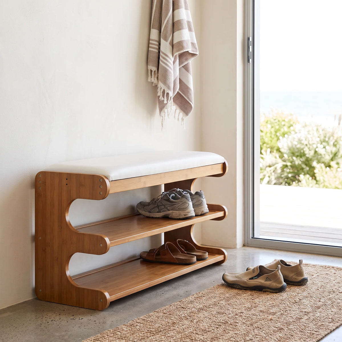Bamboo shoe storage bench with padded seat in natural finish, featuring a space-saving design ideal for entryway organization. 3