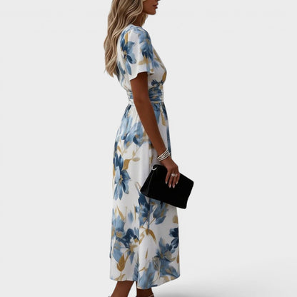 Floral wrap midi dress featuring a ruched waist and gold accents, perfect for summer weddings and elegant occasions. 1