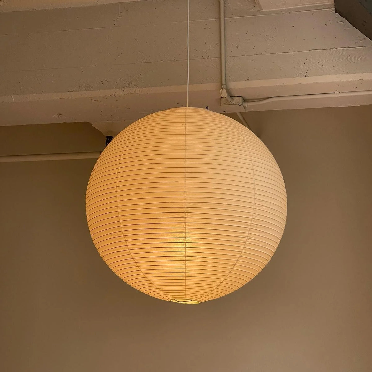 Rice Paper Pendant Lights with a ribbed shade designed for minimalist kitchen island lighting, showcasing a hardwired design available in multiple sizes. 2