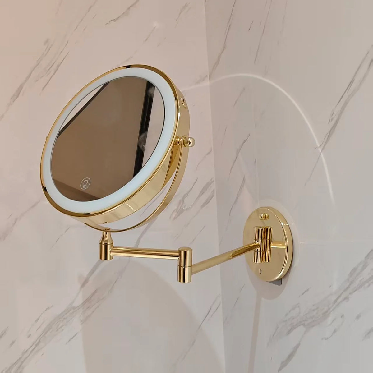 Wall mounted makeup mirror with LED light and magnification in a gold stainless steel finish, perfect for enhancing your beauty routine. 1