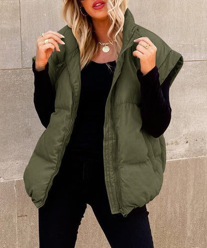 Women's black puffer vest featuring a high stand collar and zip front, designed for lightweight warmth and stylish layering. 1