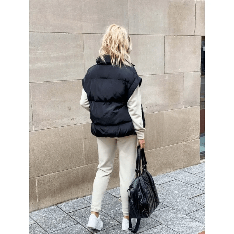 Women's black puffer vest featuring a high stand collar and zip front, designed for lightweight warmth and stylish layering. 4