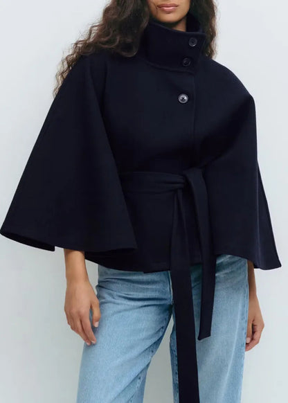 Women's cape coat featuring an adjustable waist belt and high neck, designed for elegant winter layering in a soft polyester blend fabric. 4
