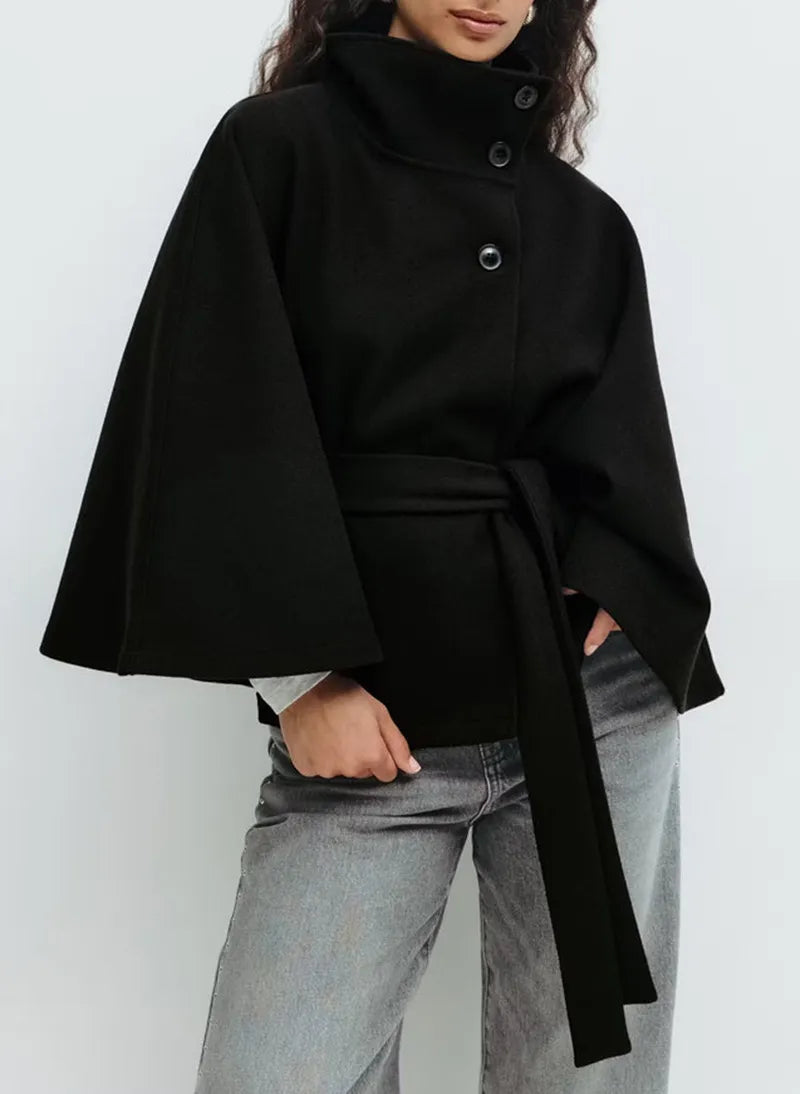 Women's cape coat featuring an adjustable waist belt and high neck, designed for elegant winter layering in a soft polyester blend fabric. 7