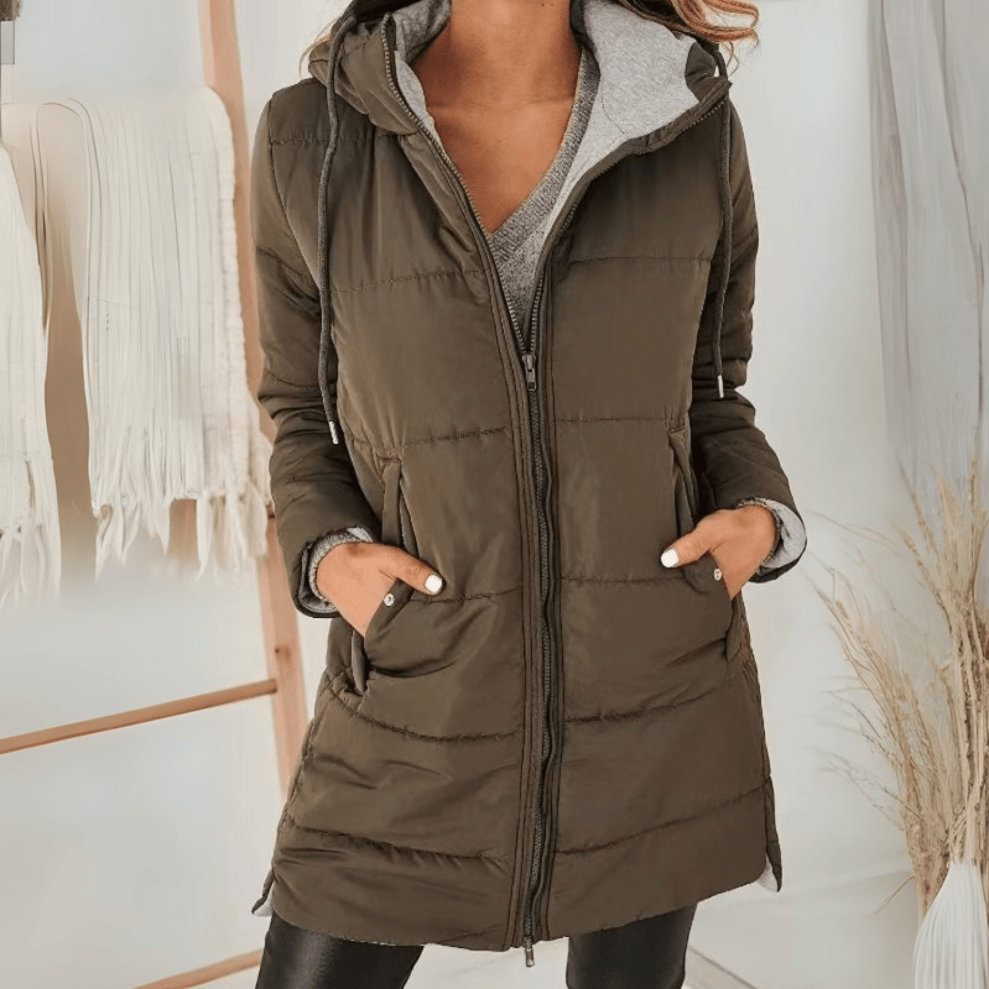 Women's longline quilted puffer jacket in black, featuring a zip front and practical pockets, ideal for cold weather wear. 4