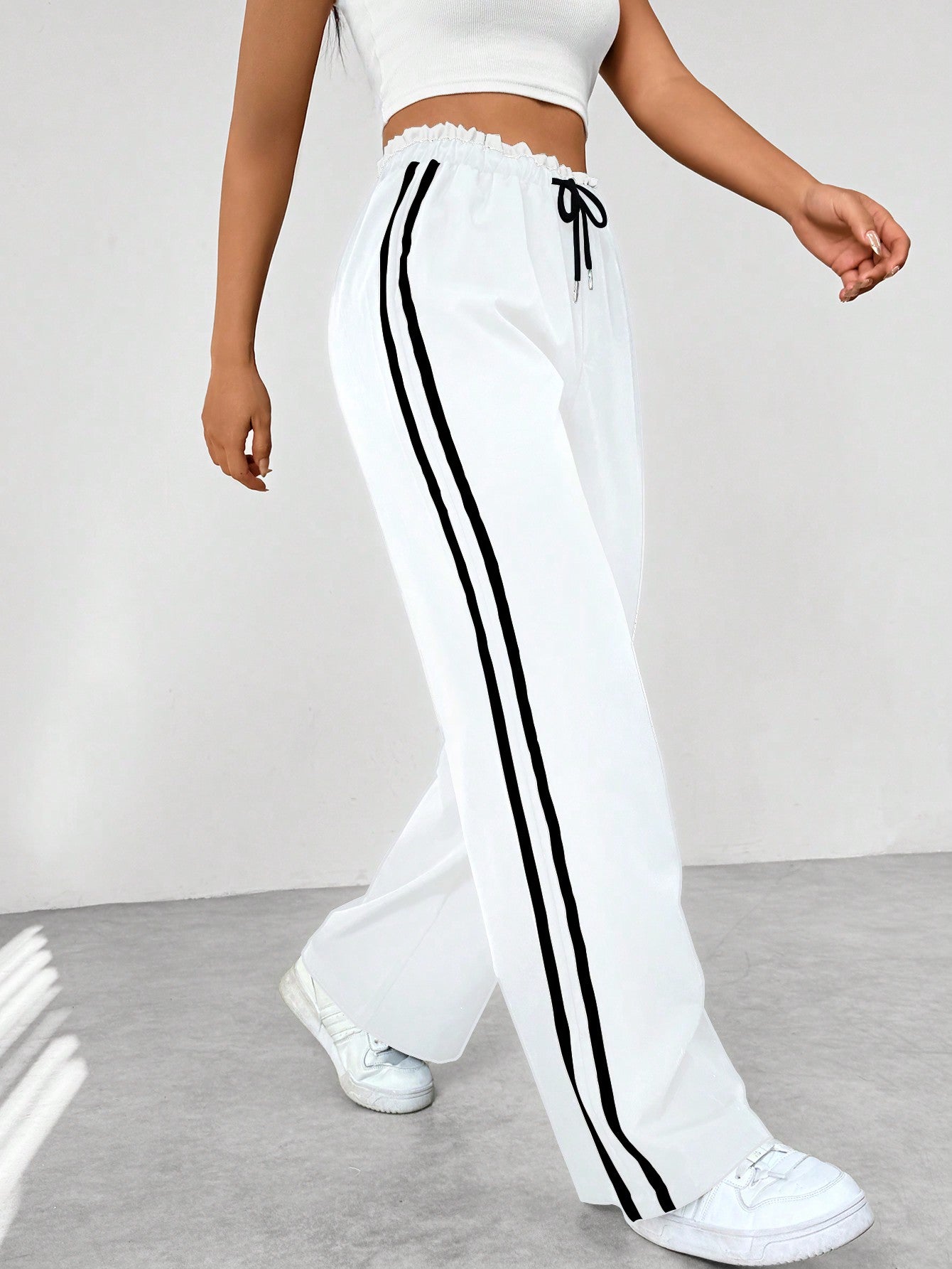 Women's wide-leg trousers featuring sporty side stripes, designed for an airy and comfortable fit, perfect for casual outings or sporty activities. 4