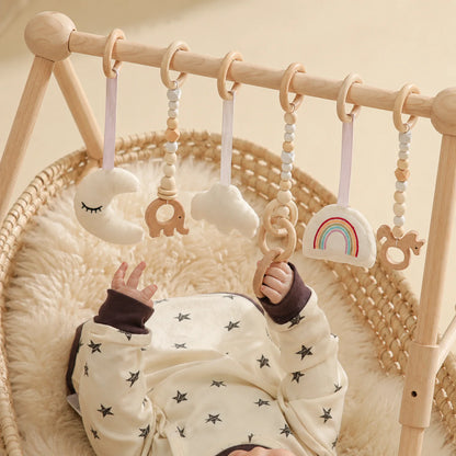 Wooden baby play gym featuring a natural wood minimalist design, equipped with colorful sensory toys for newborn and infant development. 2