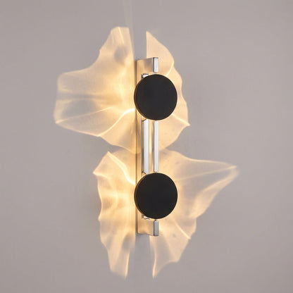 Abstract wall lamp featuring a sculptural metal design and integrated LED lighting, casting unique shadow patterns on the wall. 4