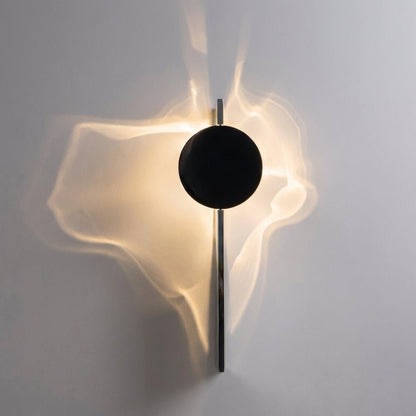 Abstract wall lamp featuring a sculptural metal design and integrated LED lighting, casting unique shadow patterns on the wall. 0