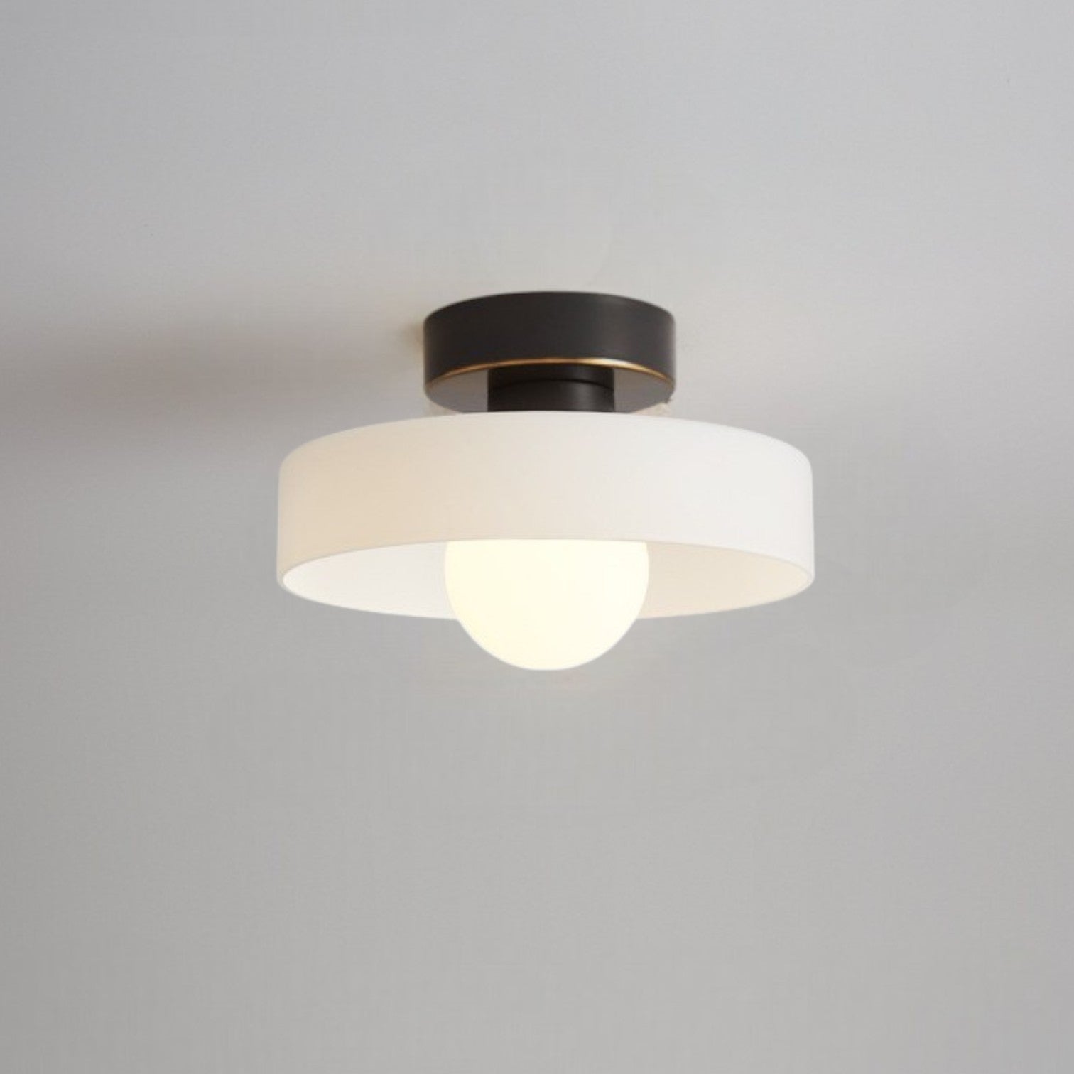 Bauhaus ceiling lamp featuring a minimalist design with a spherical glass shade and brass accents, perfect for modern bedroom decor. 0