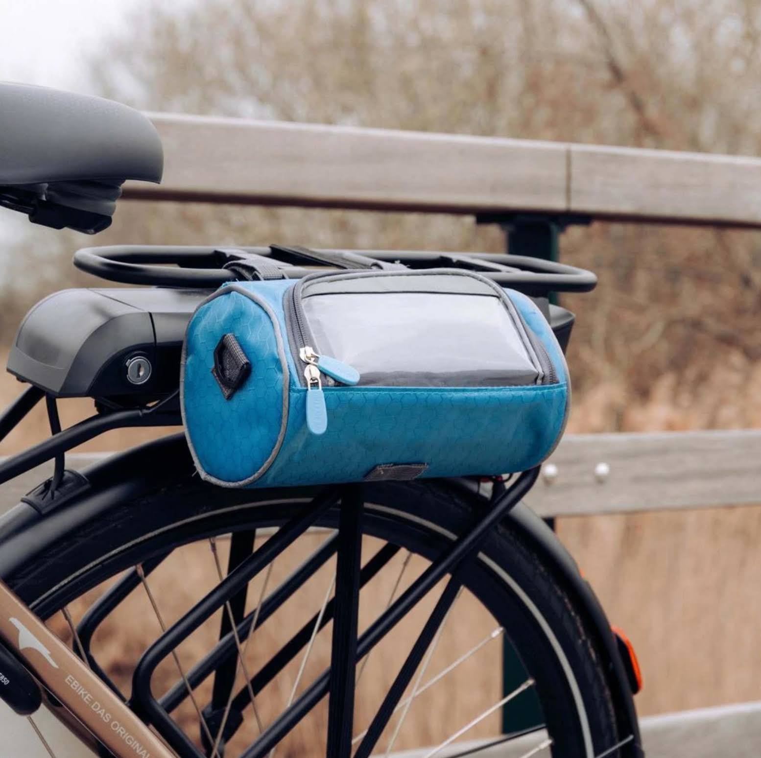 Waterproof bicycle bag with touchscreen window and secure mounting system for bike handlebars, perfect for convenient access to mobile devices while cycling. 1