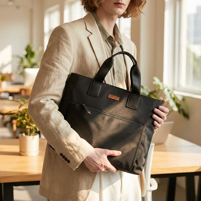 Gray and black canvas laptop bag featuring spacious compartments and an adjustable strap, designed for business commuters and men on the go. 1