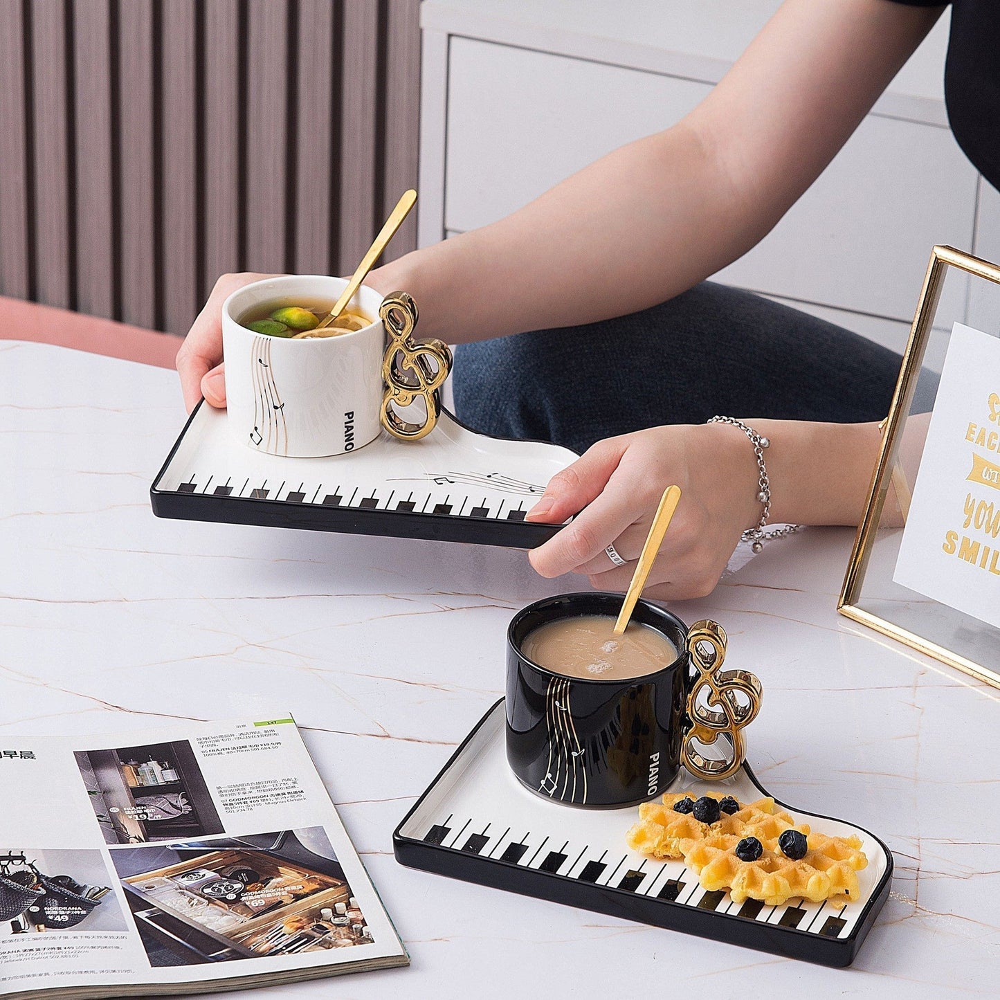Ceramic cup and tray set featuring an elegant piano motif in white and black, complemented by a gold-plated spoon. 3