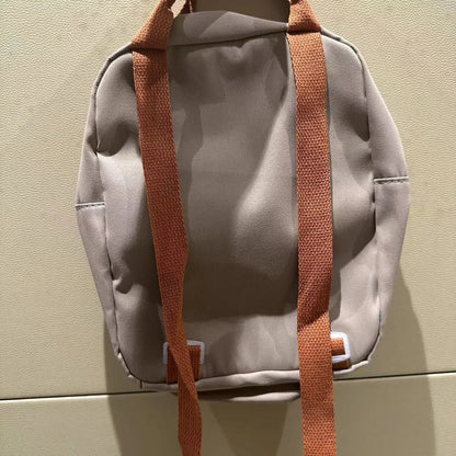 Children's dinosaur backpack featuring customizable embroidery, made from durable canvas with comfortable straps, designed in a fun multi-color pattern. 4