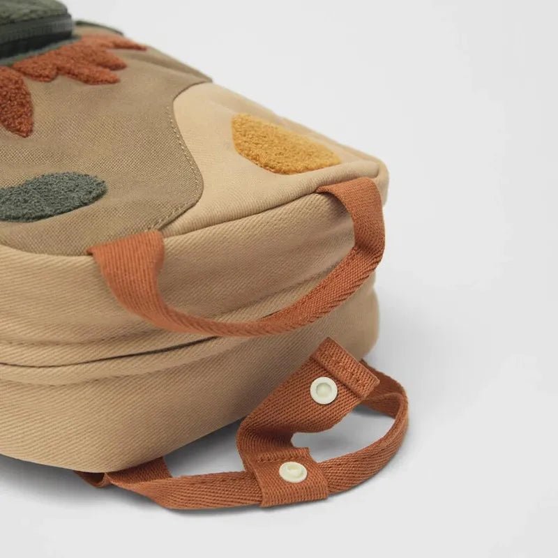Children's dinosaur backpack featuring customizable embroidery, made from durable canvas with comfortable straps, designed in a fun multi-color pattern. 5