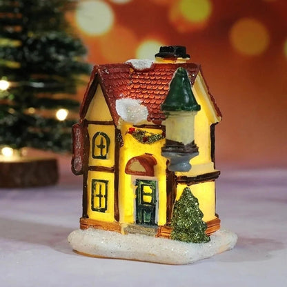 Christmas Village Decoration Set featuring snow-covered miniature houses illuminated by warm LED lights, perfect for tabletop display during the holiday season. 3