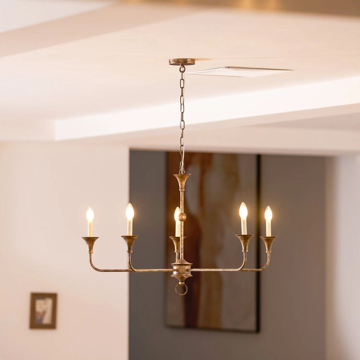 Classic chandelier light in antique brass with a candle-style design, featuring a flexible drop height, perfect for enhancing the elegance of dining rooms and entryways. 3