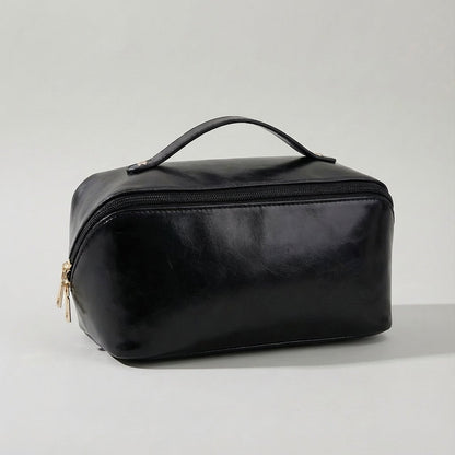 Compact travel makeup bag featuring multiple compartments and a sturdy handle, designed for organizing beauty essentials in a glossy cosmetic pouch. 4
