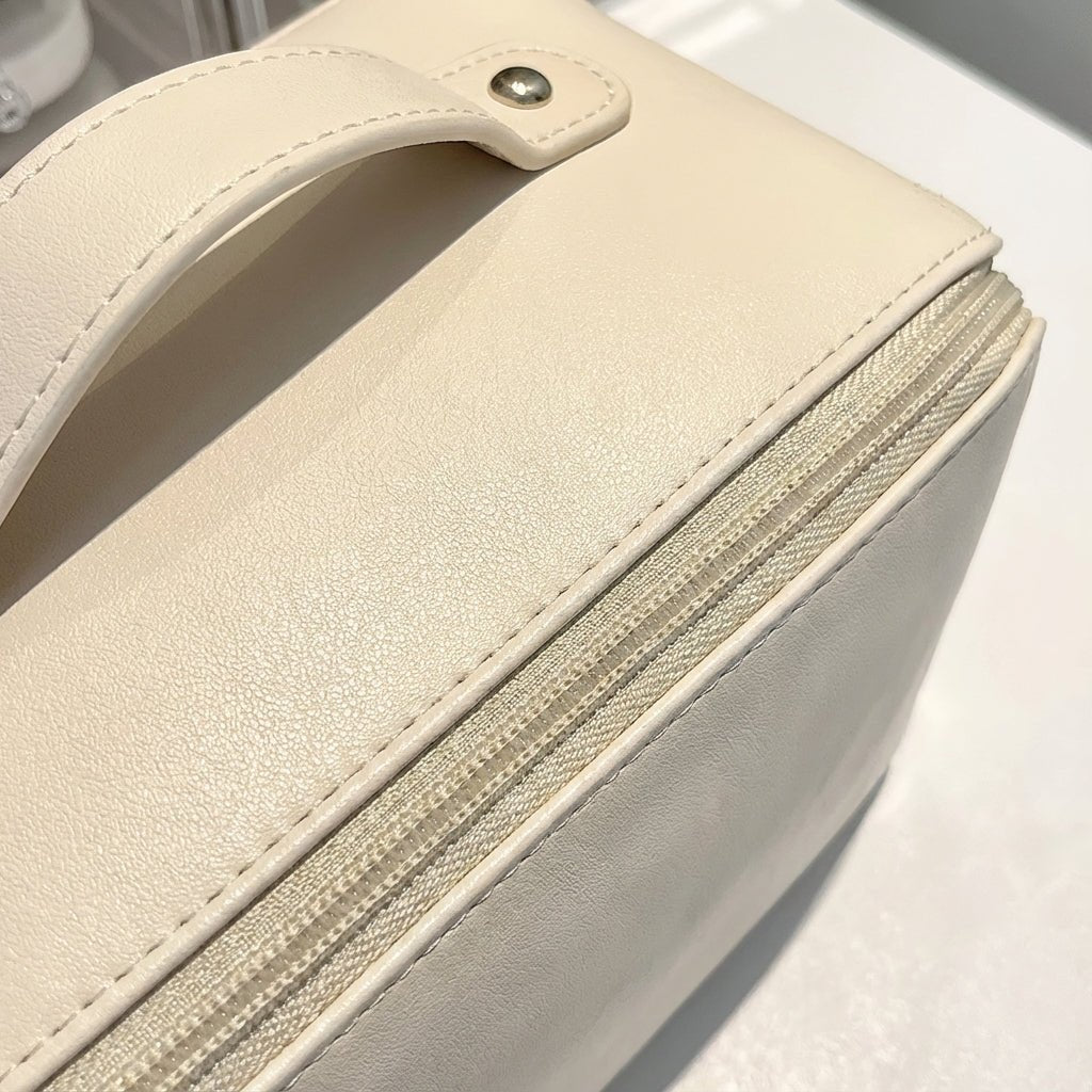 Compact travel makeup bag featuring multiple compartments and a sturdy handle, designed for organizing beauty essentials in a glossy cosmetic pouch. 3
