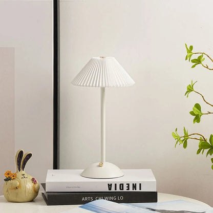 Scandinavian style cordless table lamp featuring a pleated fabric shade and sturdy iron base, perfect for enhancing the ambiance of bedrooms or dining areas. 12