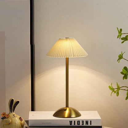 Scandinavian style cordless table lamp featuring a pleated fabric shade and sturdy iron base, perfect for enhancing the ambiance of bedrooms or dining areas. 1