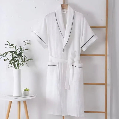 Cotton bathrobe for women with short sleeves, featuring a relaxed fit in double muslin fabric, designed for breathability and lightweight comfort. 1