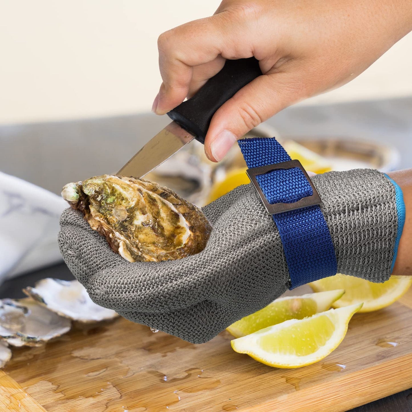 Cut resistant gloves featuring adjustable cuffs made of durable stainless steel mesh, designed for safe handling and protection in industrial and kitchen environments. 1