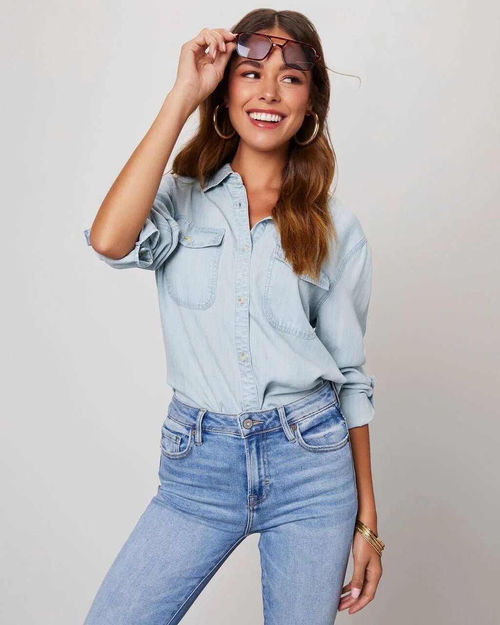 Denim shirt for women featuring a button front, long sleeves, classic collar, and curved hemline. 8