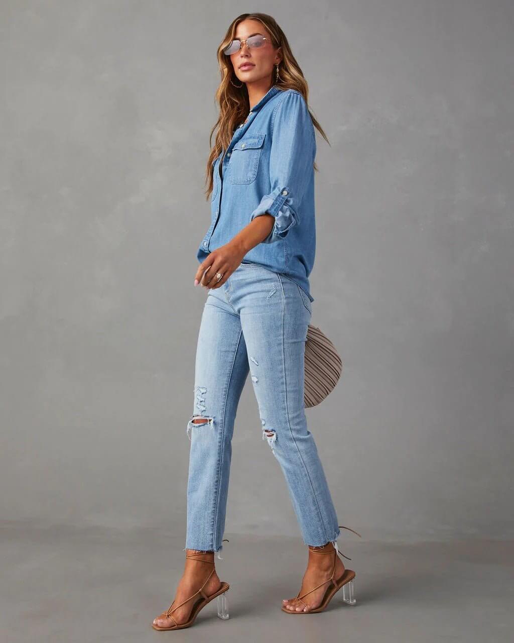Denim shirt for women featuring a button front, long sleeves, classic collar, and curved hemline. 3