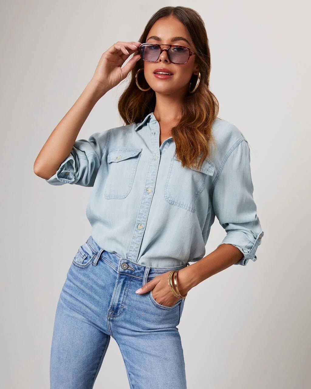 Denim shirt for women featuring a button front, long sleeves, classic collar, and curved hemline. 6
