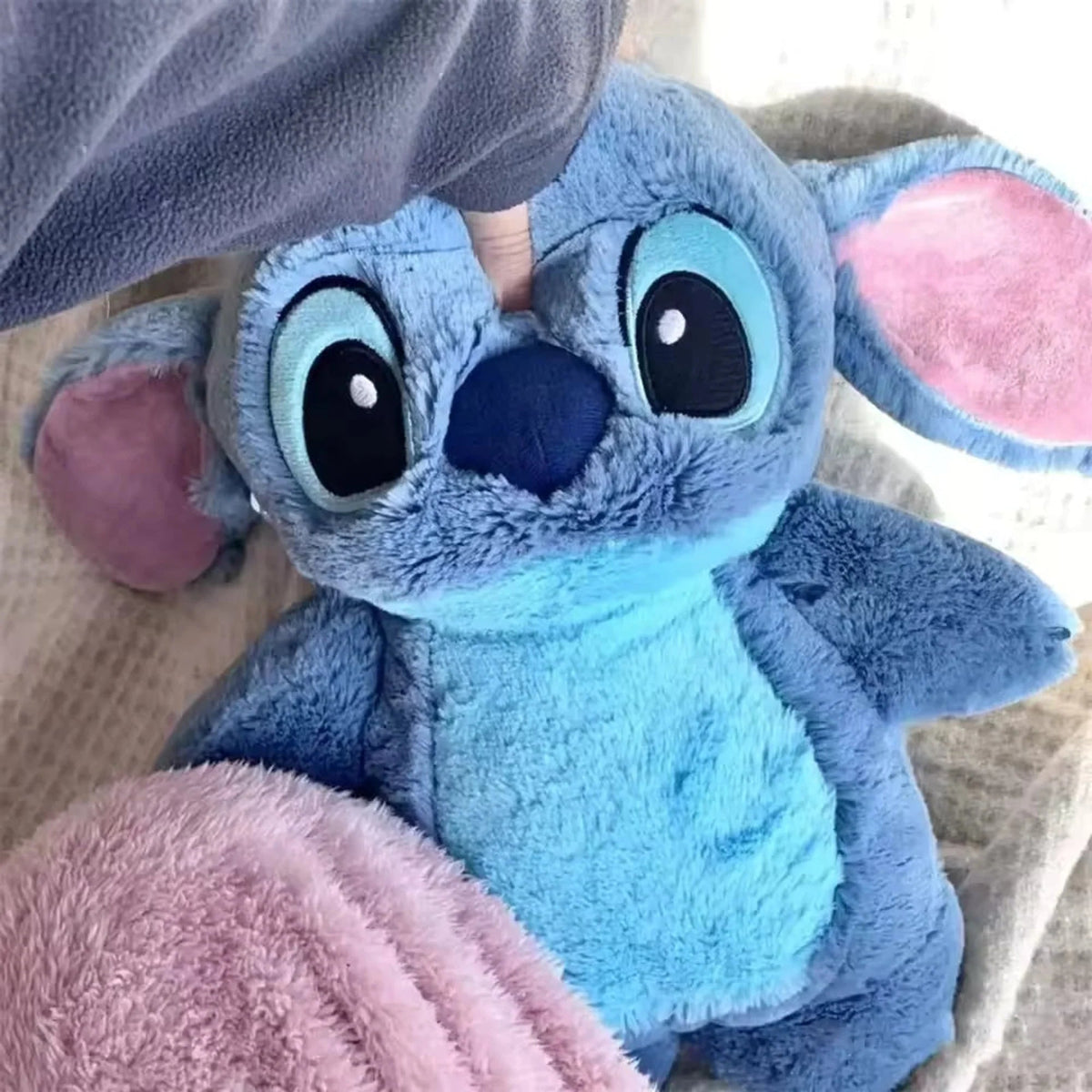 Extra large plush hot water bottle featuring a soft Stitch cover, perfect for cozying up during winter as a hand warmer. 0