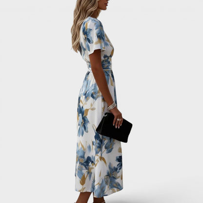 Floral wrap midi dress featuring a ruched waist and gold accents, perfect for summer weddings and elegant occasions. 1