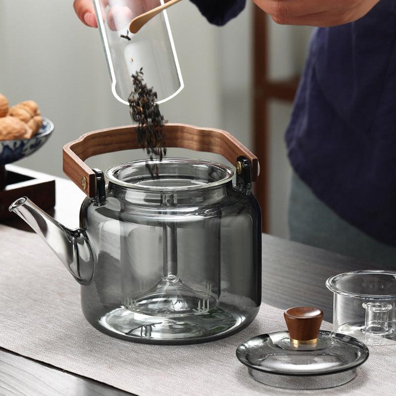 Elegant smoked glass teapot with infuser and wooden lid, perfect for brewing 1.2L of tea, combining style and functionality. 1