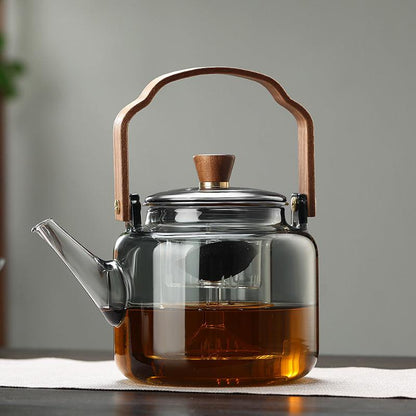 Elegant smoked glass teapot with infuser and wooden lid, perfect for brewing 1.2L of tea, combining style and functionality. 0