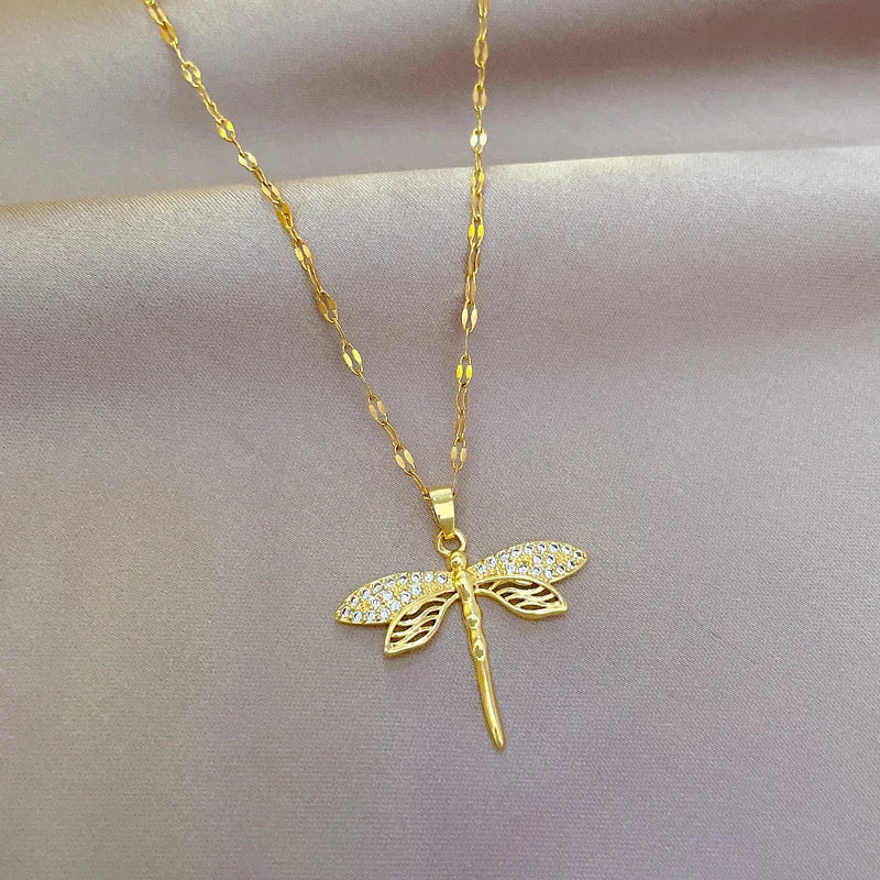 Gold dragonfly necklace featuring a sparkling crystal pendant on a 14K gold eye chain, perfect for adding an elegant touch to any outfit. 0