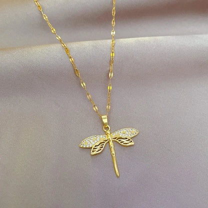 Gold dragonfly necklace featuring a sparkling crystal pendant on a 14K gold eye chain, perfect for adding an elegant touch to any outfit. 0