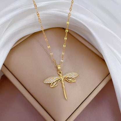 Gold dragonfly necklace featuring a sparkling crystal pendant on a 14K gold eye chain, perfect for adding an elegant touch to any outfit. 2