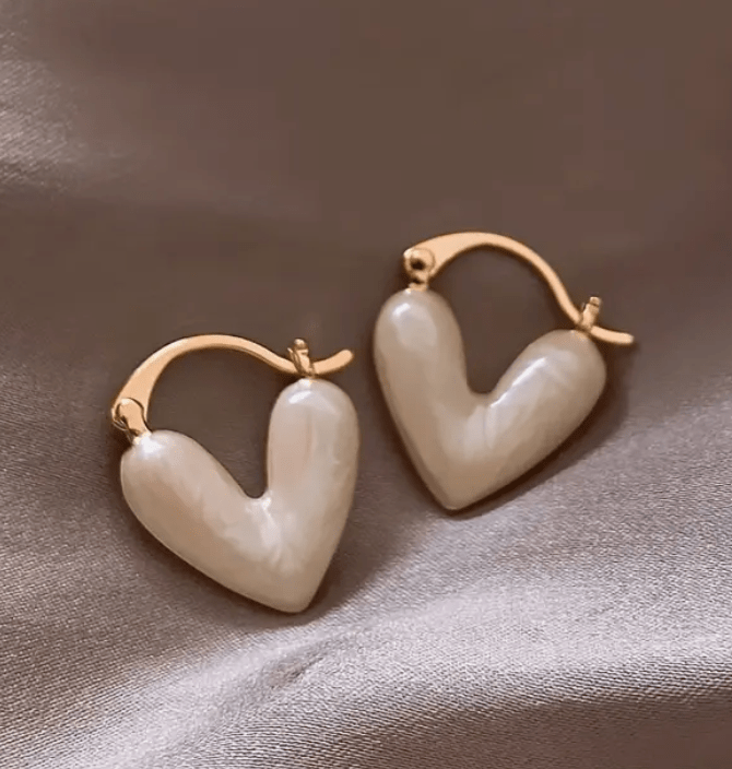 Heart-shaped earrings featuring a pearl accent, crafted from durable metal, showcasing an elegant design perfect for women's fashion. 0