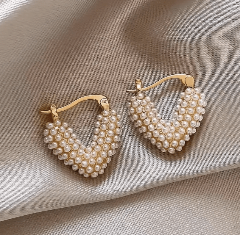 Heart-shaped earrings featuring a pearl accent, crafted from durable metal, showcasing an elegant design perfect for women's fashion. 4