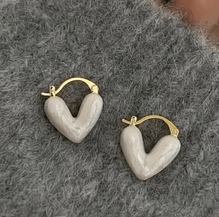 Heart-shaped earrings featuring a pearl accent, crafted from durable metal, showcasing an elegant design perfect for women's fashion. 1