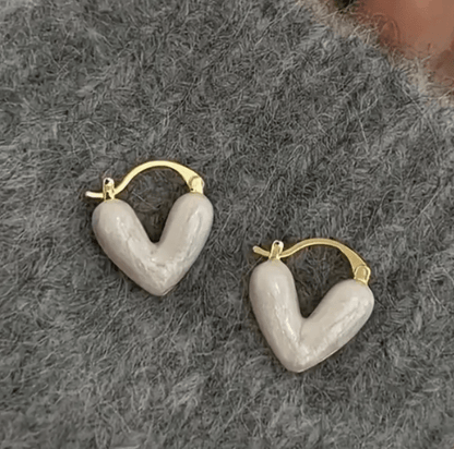 Heart-shaped earrings featuring a pearl accent, crafted from durable metal, showcasing an elegant design perfect for women's fashion. 1