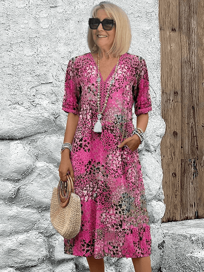 Knee-length V-neck summer dress featuring a vibrant floral pattern and convenient side pockets, designed for comfort in plus sizes. 2