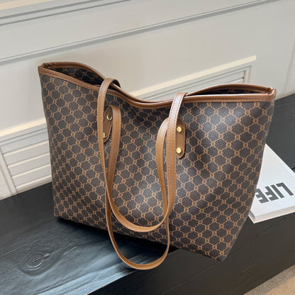 Large black zipper tote bag with shoulder strap, perfect for shopping and travel, featuring spacious interior and stylish design. 1