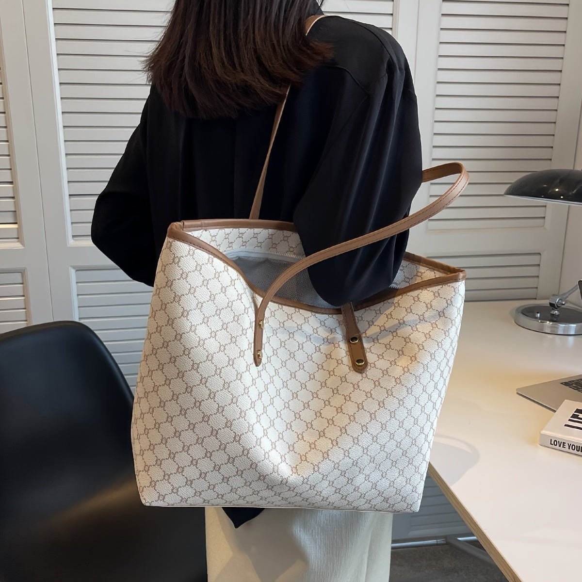 Large black zipper tote bag with shoulder strap, perfect for shopping and travel, featuring spacious interior and stylish design. 2