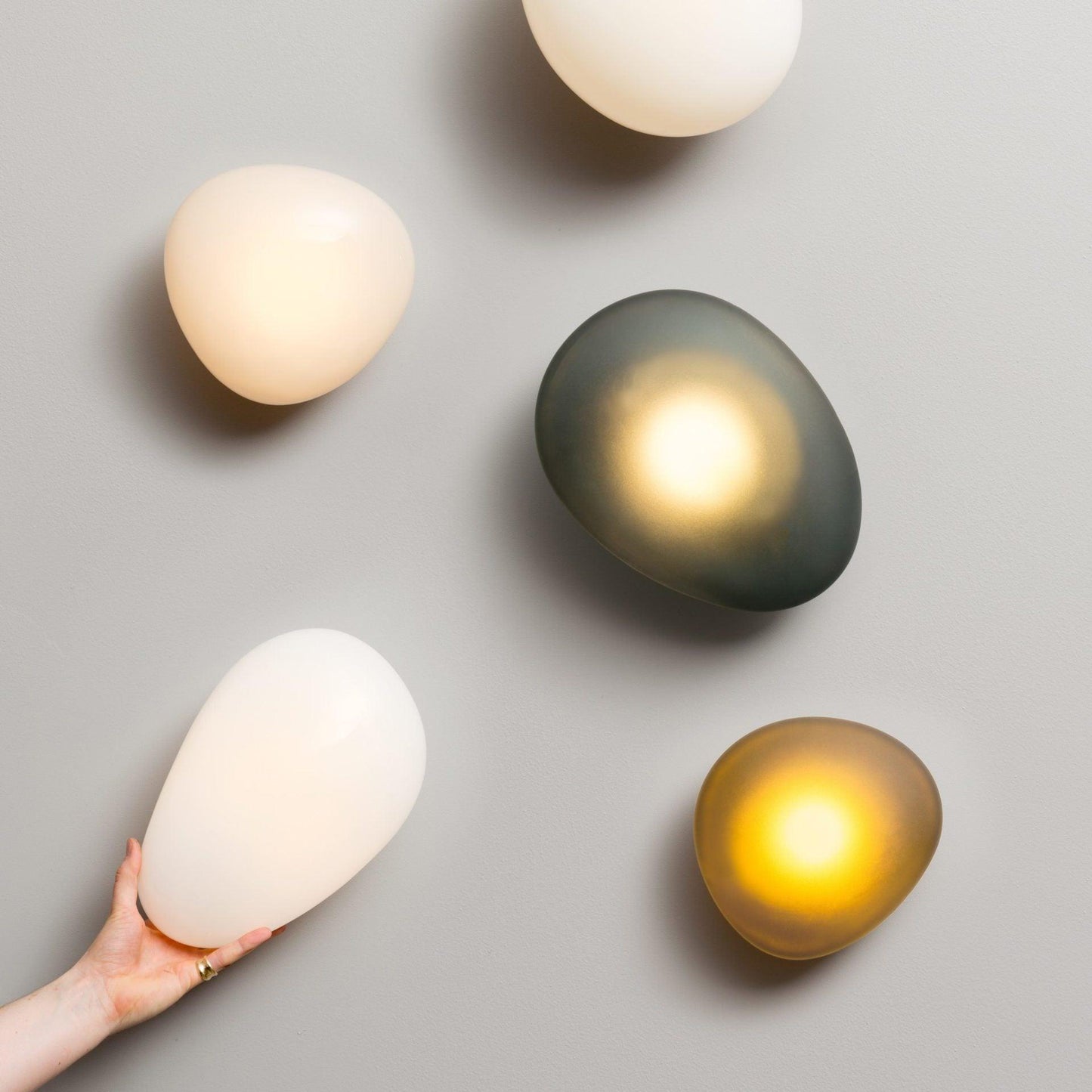 LED wall lamp featuring an adjustable light color, designed with a sleek oval shape in metal and glass, perfect for modern home decor. 6