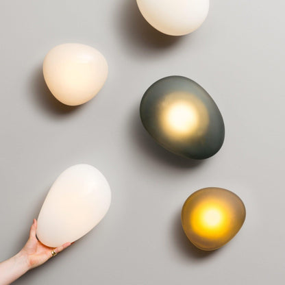 LED wall lamp featuring an adjustable light color, designed with a sleek oval shape in metal and glass, perfect for modern home decor. 6