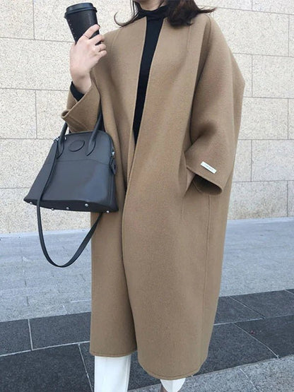 Long wool coat for women featuring a relaxed fit and minimalist design, perfect for autumn and winter fashion. 1