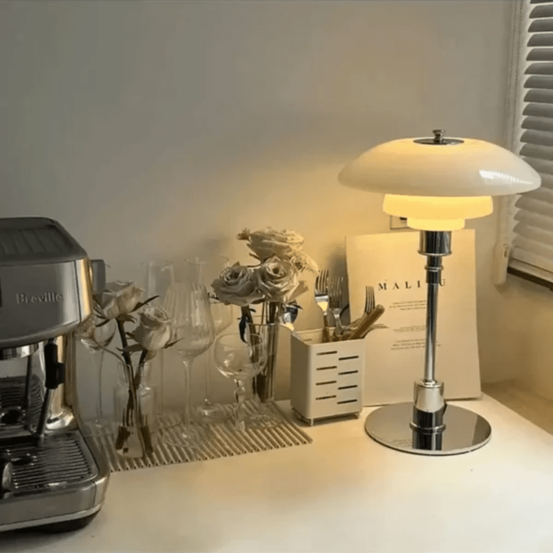Minimalist table lamp featuring a warm LED light and elegant glass shade, ideal for bedside or desk use, with a sleek modern metal base. 1